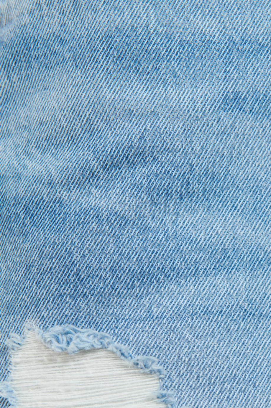 Bermuda tiro bajo de jean azul clara con rotos en frente