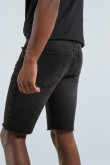 Bermuda gris oscura en jean con tiro bajo, rotos y bordes deshilados