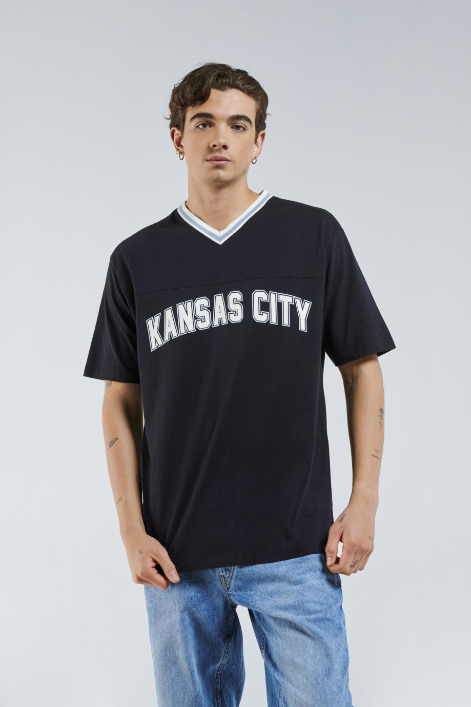 Camiseta azul oversize con diseñoss college y cuello en V