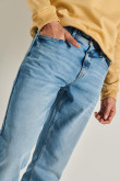 Jean slim azul con desgastes, bota ajustada y tiro bajo