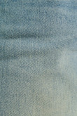 Jean azul claro slim con desgastes localizados y tiro bajo