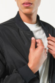 Chaqueta bomber negra con cremallera y bolsillos con tapa