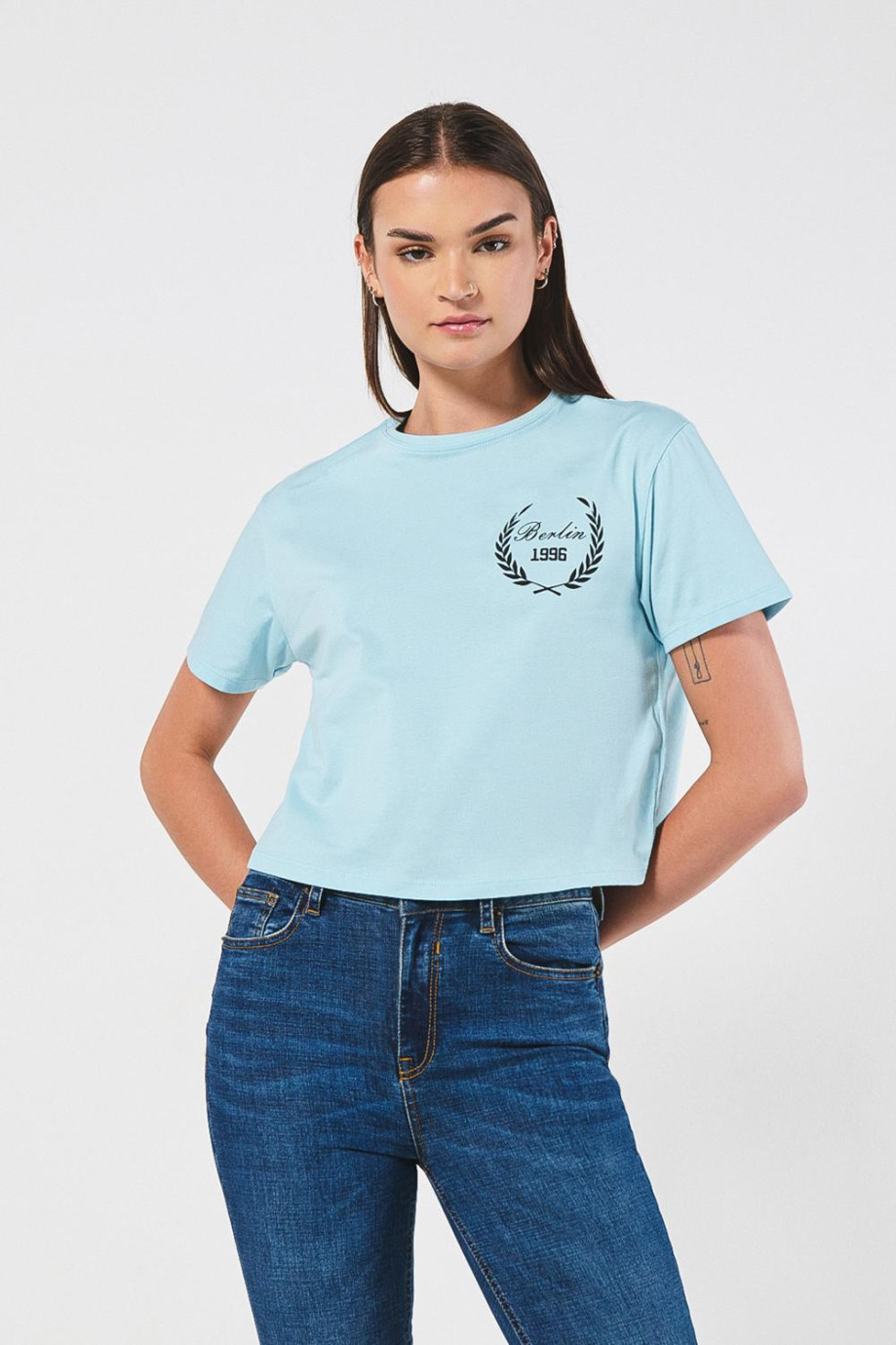 Camiseta crop top azul clara con arte college en frente