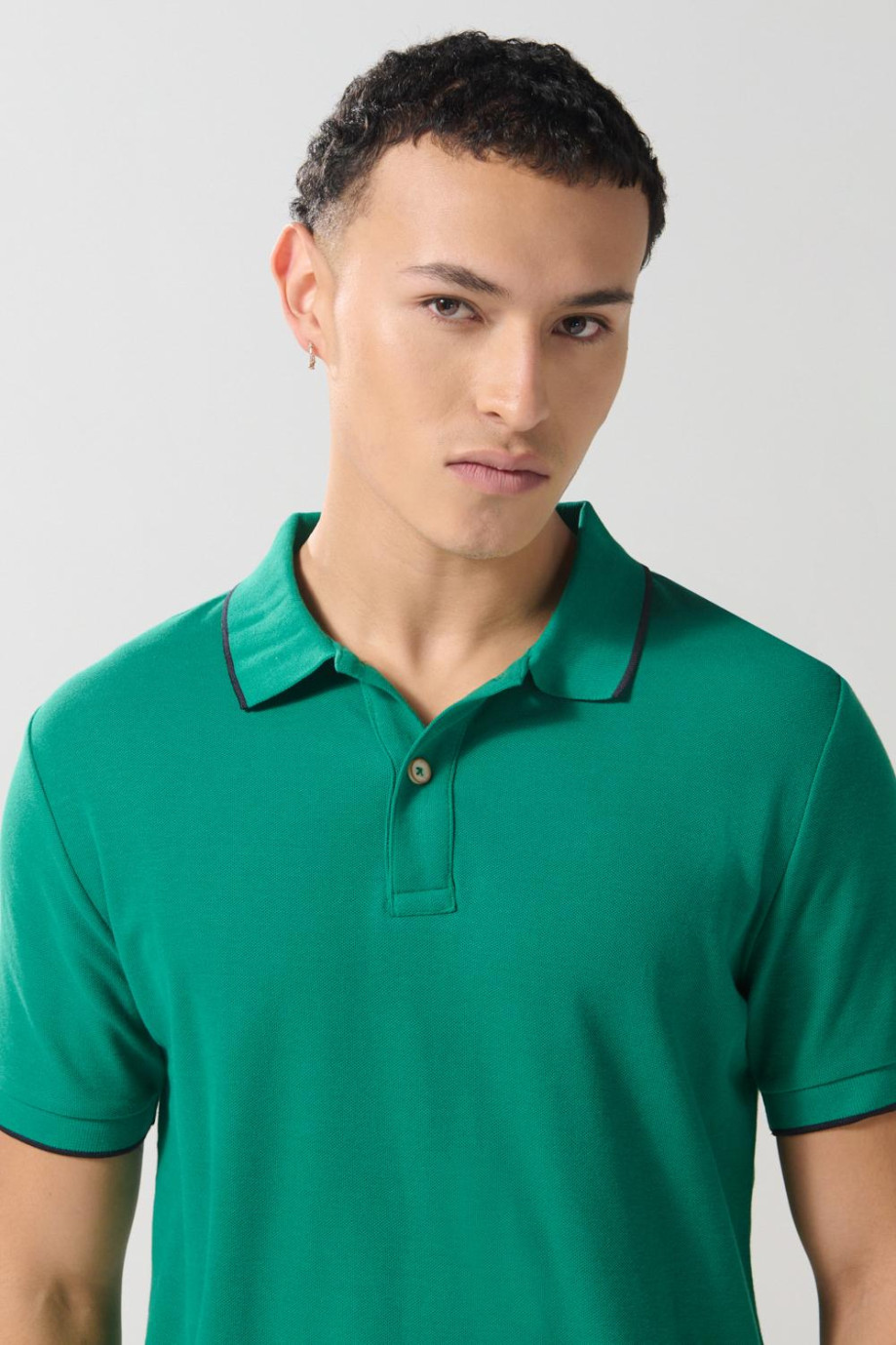 Camiseta unicolor tipo polo con aberturas y manga corta