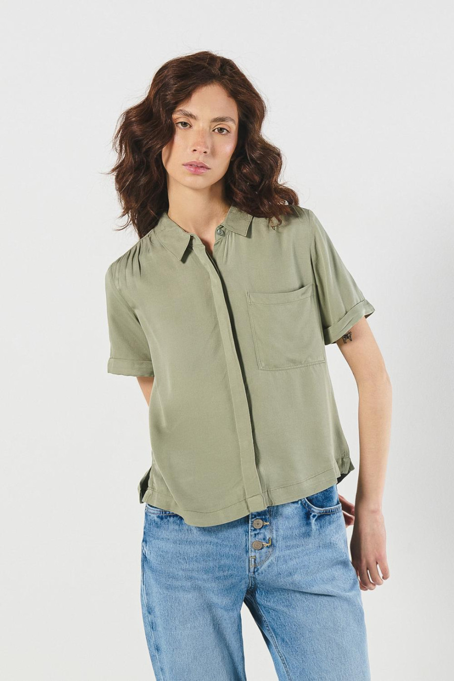Blusa unicolor con cuello camisero y bolsillo cuadrado