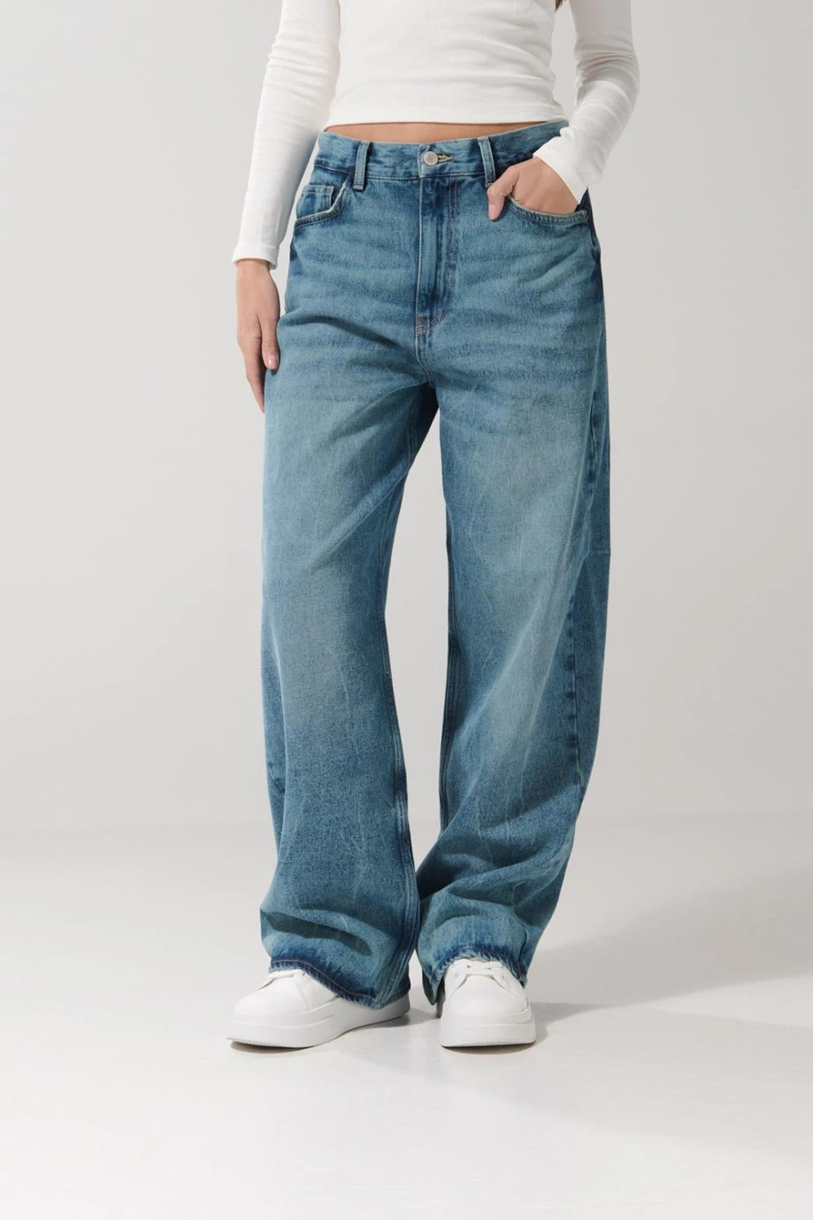 Jean baggy tiro medio azul claro con desgastes y bota ancha