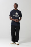 Camiseta básica hombro rodado masculina, manga corta, cuello redondo, con estampado tipo college.