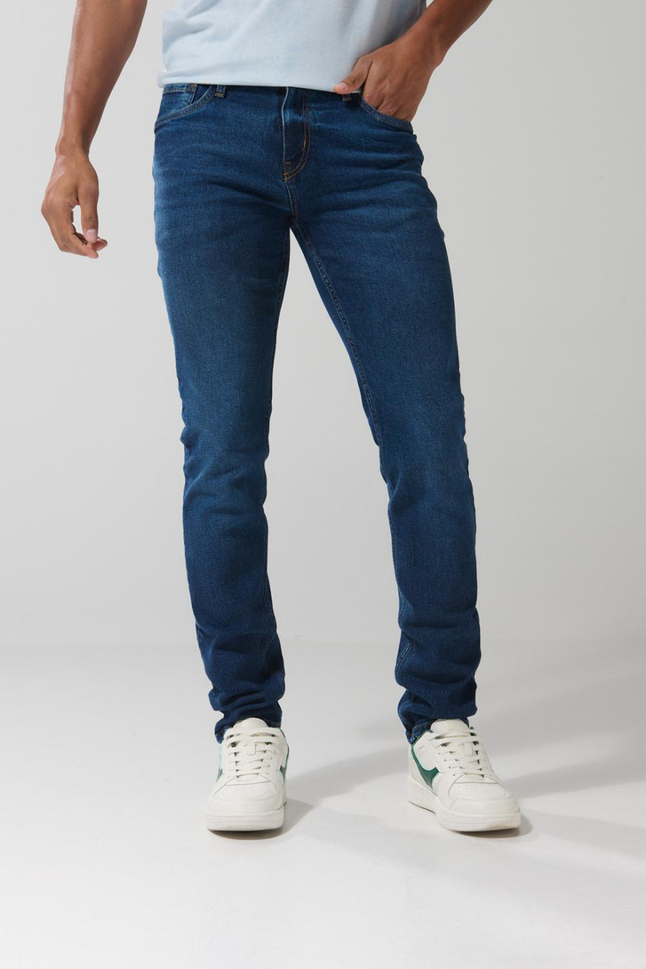 Jean azul oscuro tipo slim con tiro bajo y botón visible