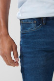 Jean azul oscuro tipo slim con tiro bajo y botón visible