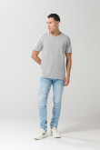 Jean azul claro skinny con desgastes localizados y tiro bajo