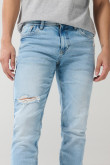 Jean azul claro skinny con desgastes localizados y tiro bajo