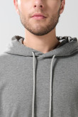 Buzo gris claro oversize con capota y bolsillo en frente