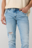 Jean azul claro tipo skinny tiro bajo con desgastes sutiles