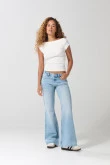 Jean flare azul claro con bota ancha, desgastes y tiro medio