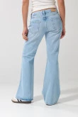 Jean flare azul claro con bota ancha, desgastes y tiro medio