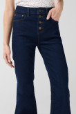 Jean flare azul con botones visibles, tiro alto y bota ancha