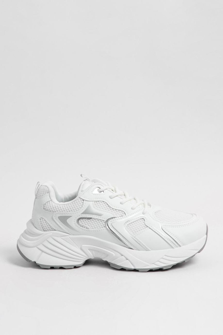 Tenis chunky blancos con detalles en contraste plateado.
