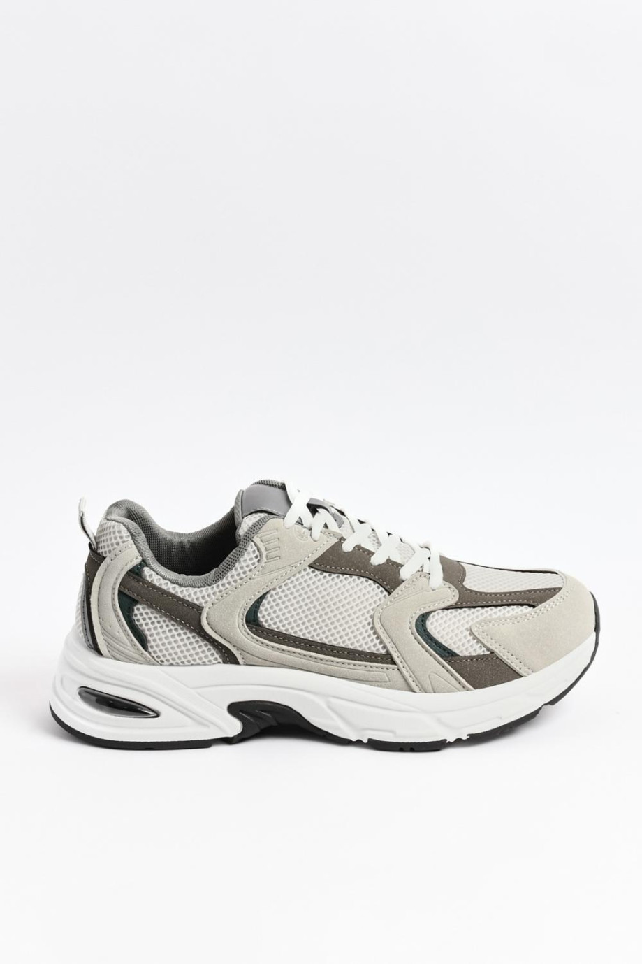 Tenis chunky deportivos en color gris humo con suela blanca.