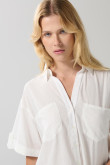 Blusa unicolor con botones, doble bolsillo y manga corta