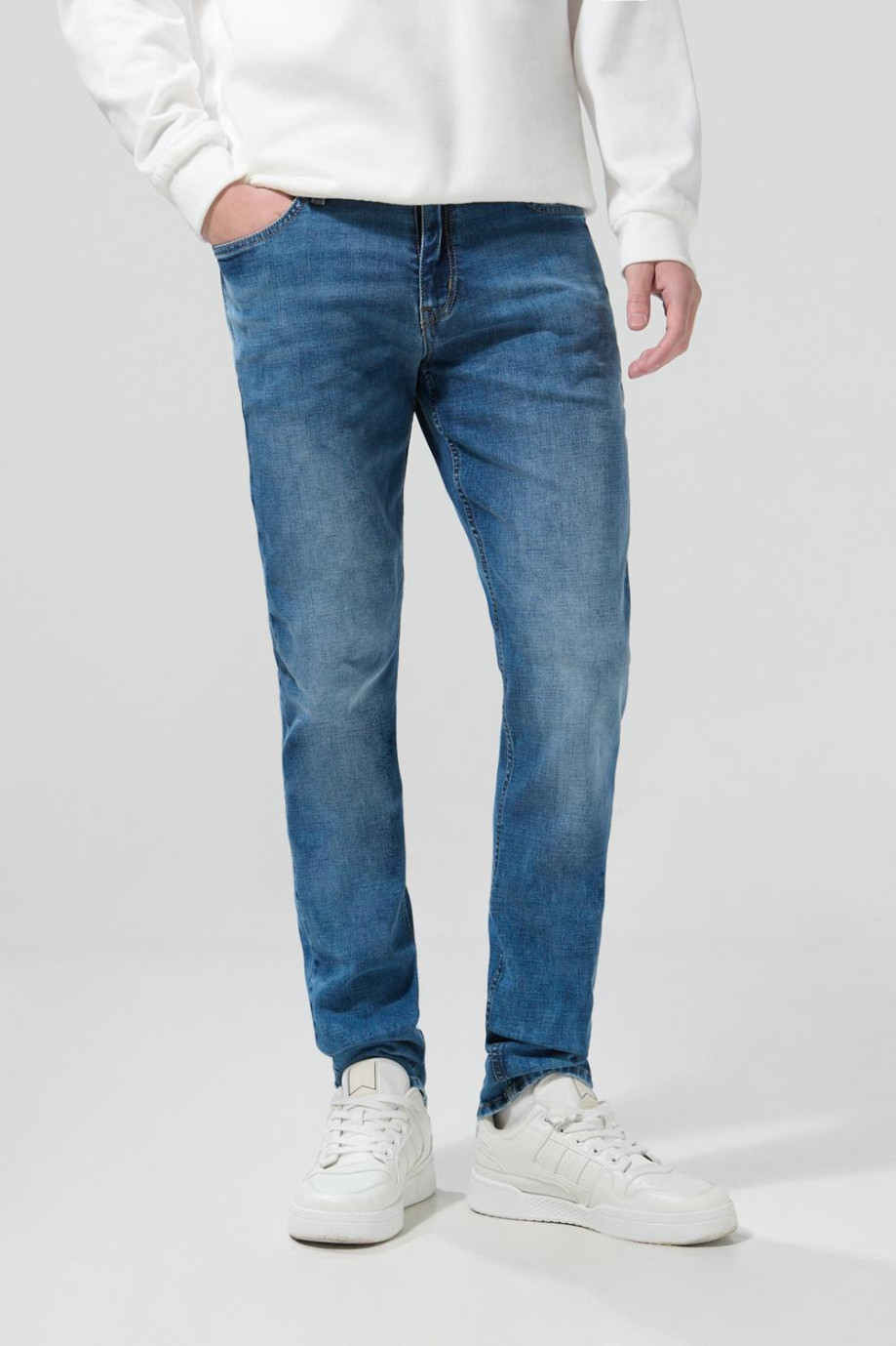 Jean slim azul medio con ligeros desgastes y tiro bajo