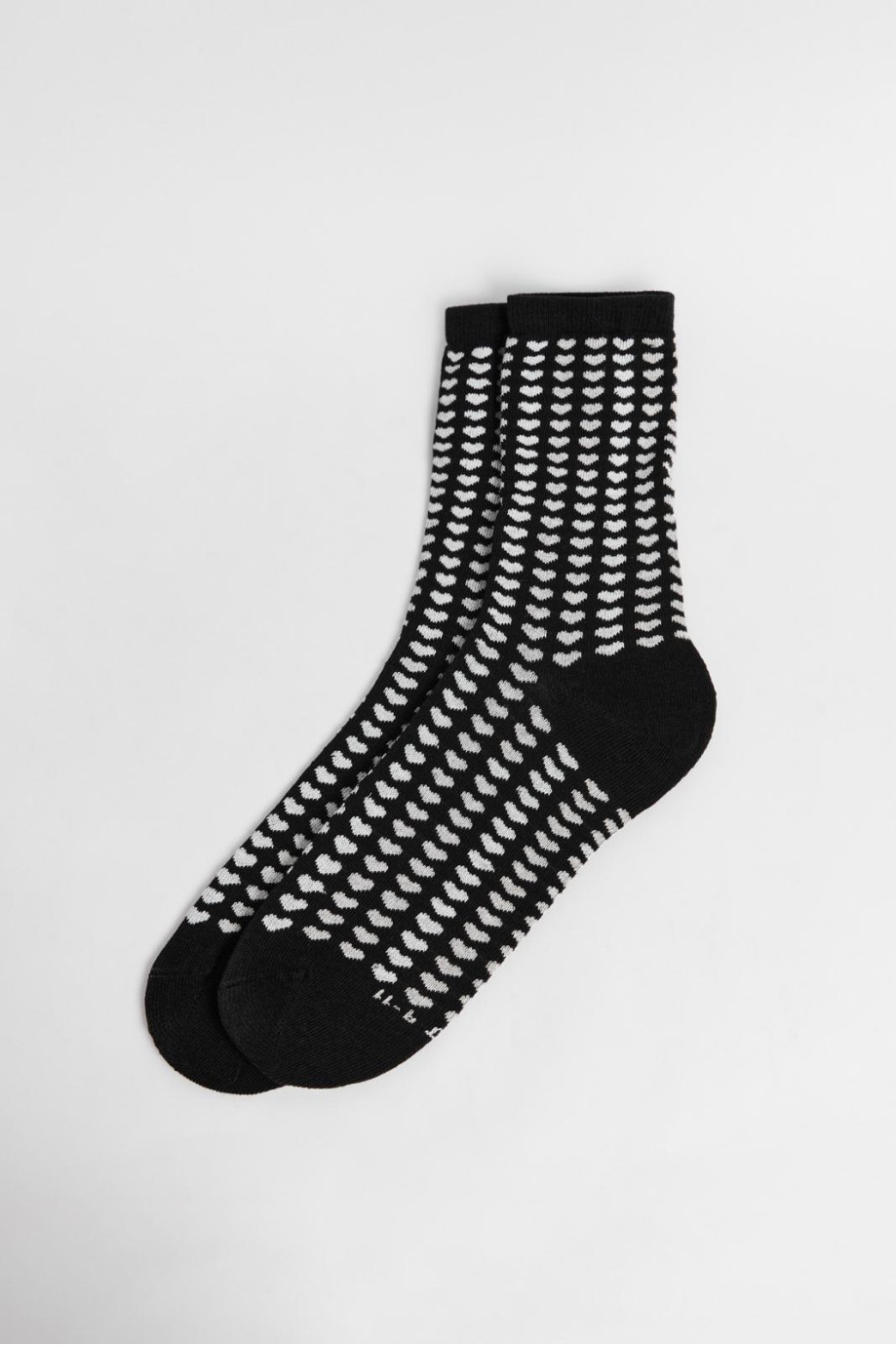 Medias negras largas con diseños de corazones blancos