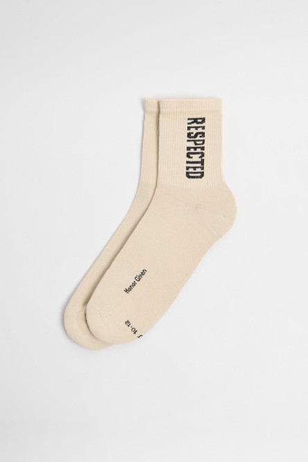 Medias kakis claras largas con texto negro lateral