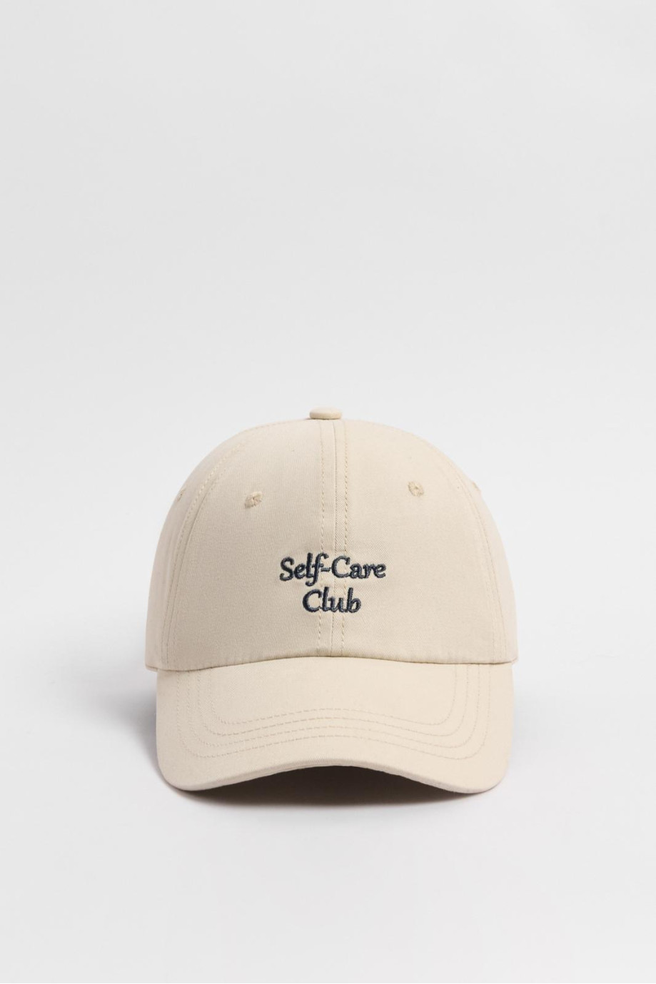 Cachucha crema clara beisbolera con texto en frente