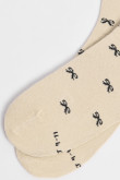 Medias largas crema con diseño de moños.