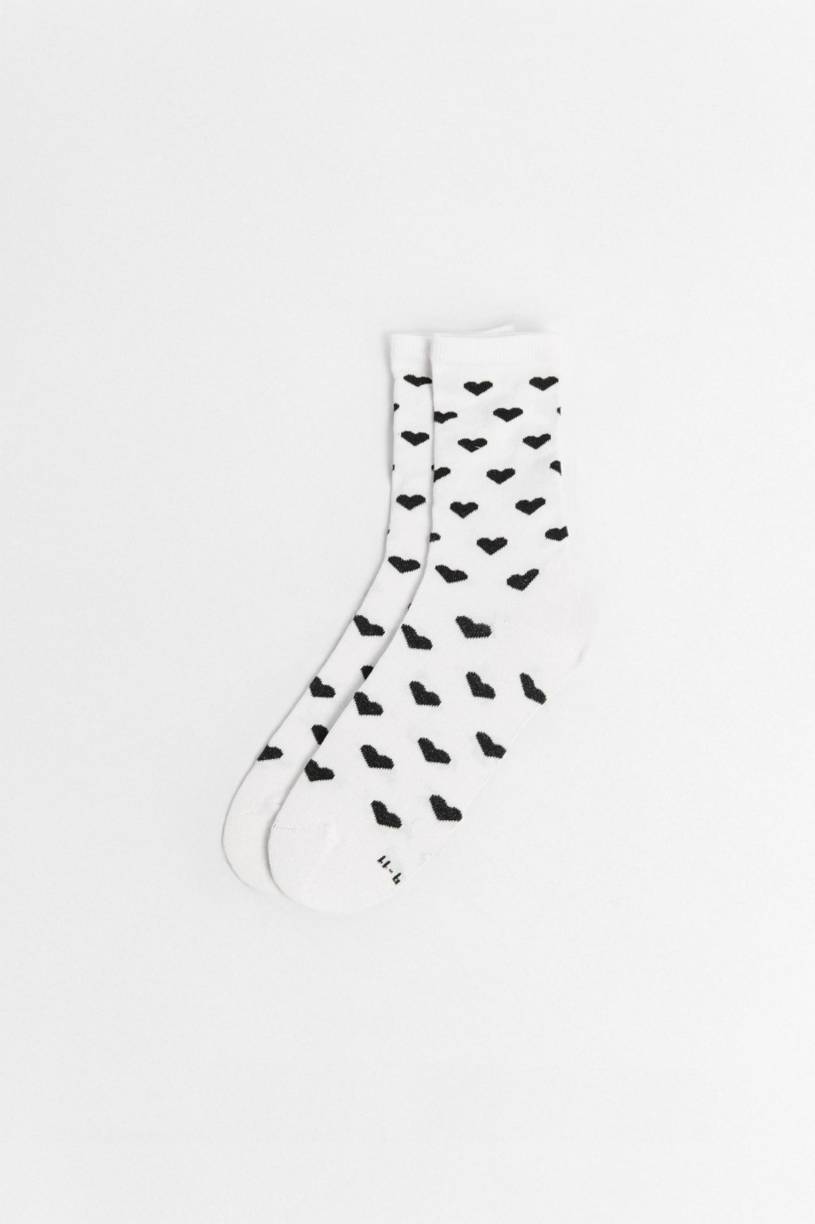 Medias largas crema con diseño de corazones.