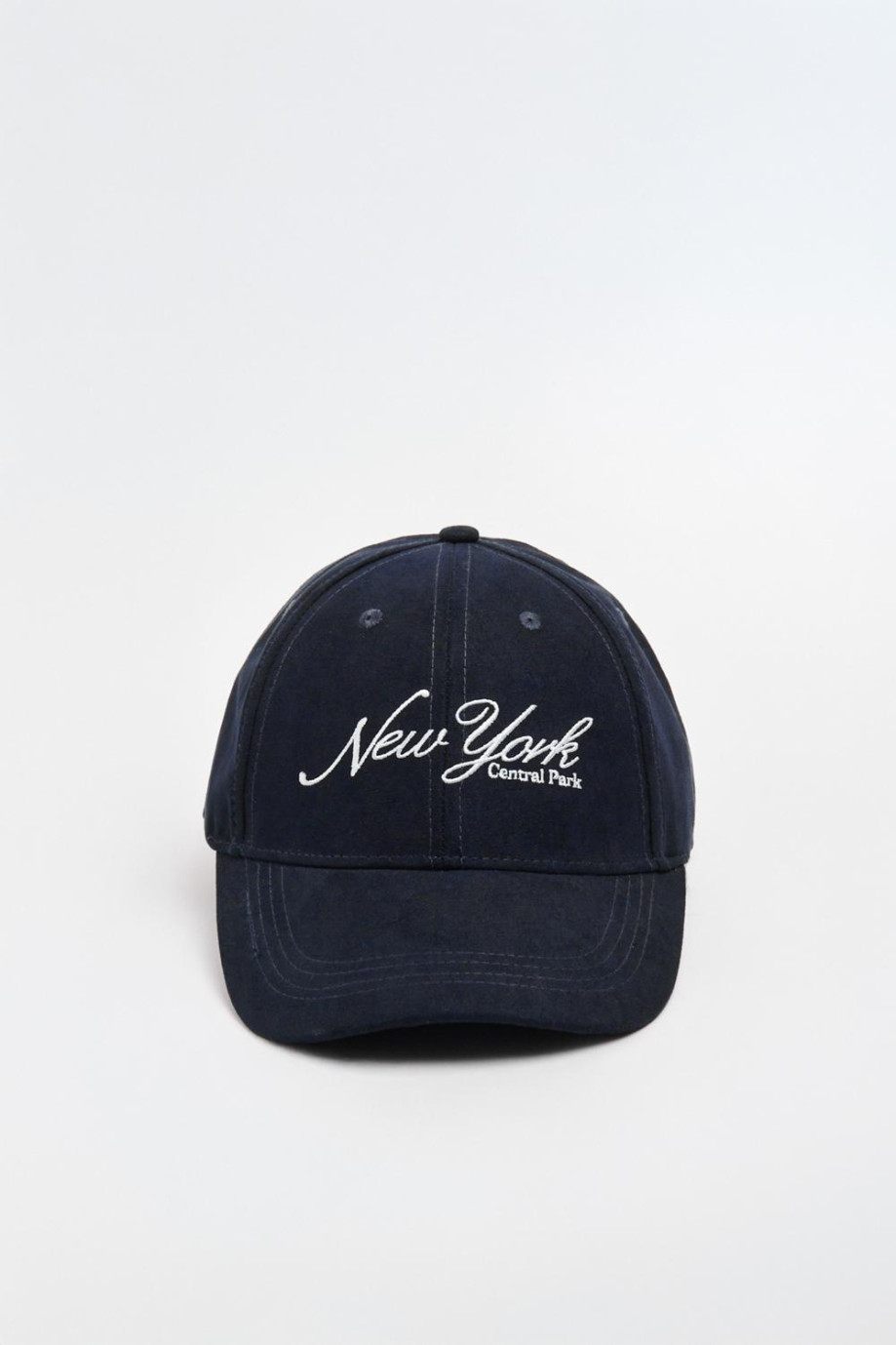 Gorra beisbolera en color azul, con refuerzo, cierre plástico y aplique bordado "New York".