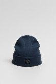 Gorro tejido unicolor con marquilla decorativa en frente