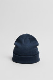 Gorro tejido unicolor con marquilla decorativa en frente