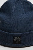 Gorro tejido unicolor con marquilla decorativa en frente