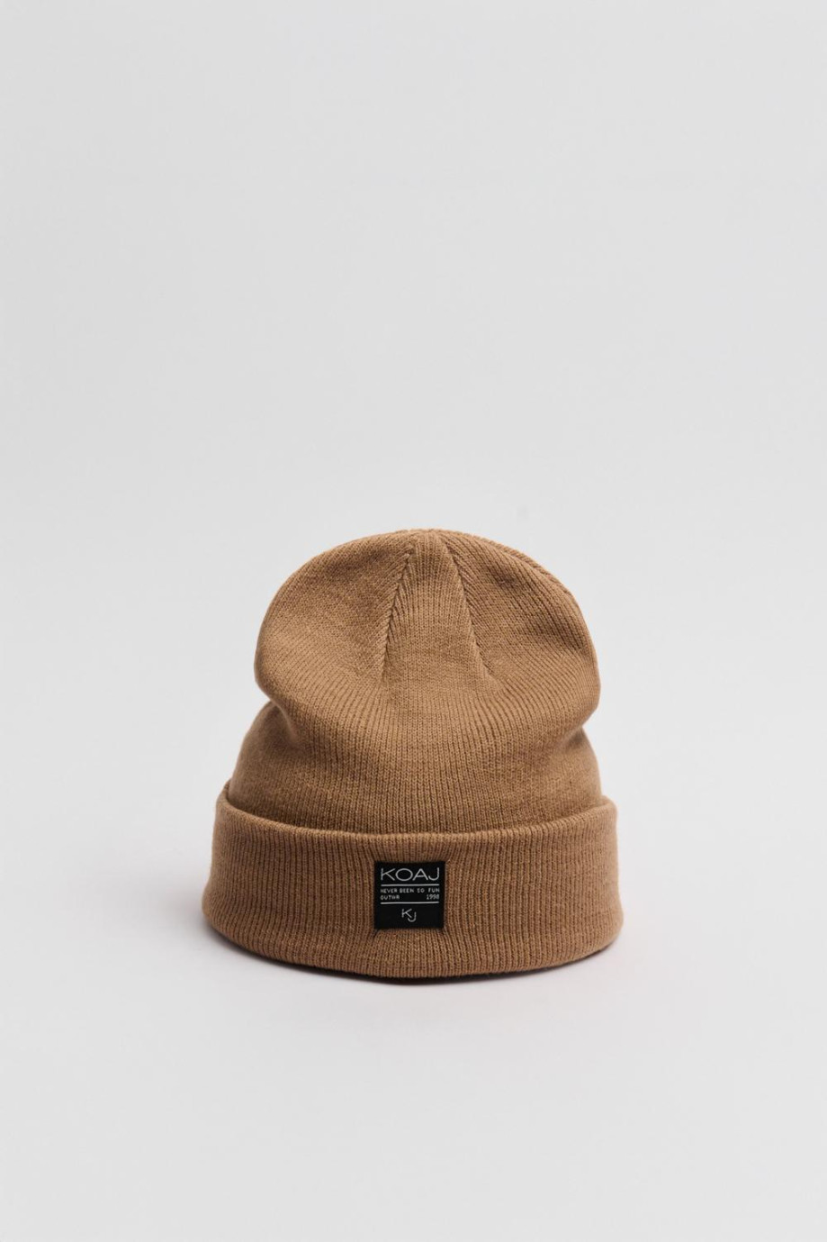 Gorro tejido unicolor con marquilla decorativa en frente
