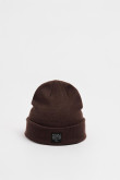 Gorro tejido unicolor con marquilla decorativa en frente