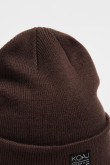 Gorro tejido unicolor con marquilla decorativa en frente
