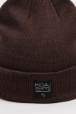 Gorro tejido unicolor con marquilla decorativa en frente