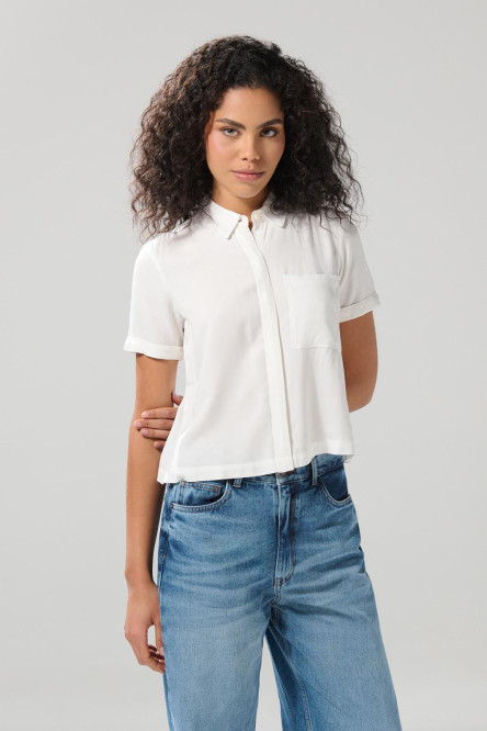 Blusa unicolor con cuello camisero y bolsillo en frente