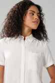 Blusa unicolor con cuello camisero y bolsillo en frente