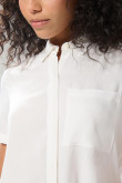 Blusa unicolor con cuello camisero y bolsillo en frente