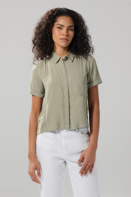 Blusa unicolor con cuello camisero y bolsillo en frente
