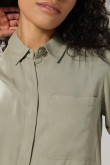Blusa unicolor con cuello camisero y bolsillo en frente