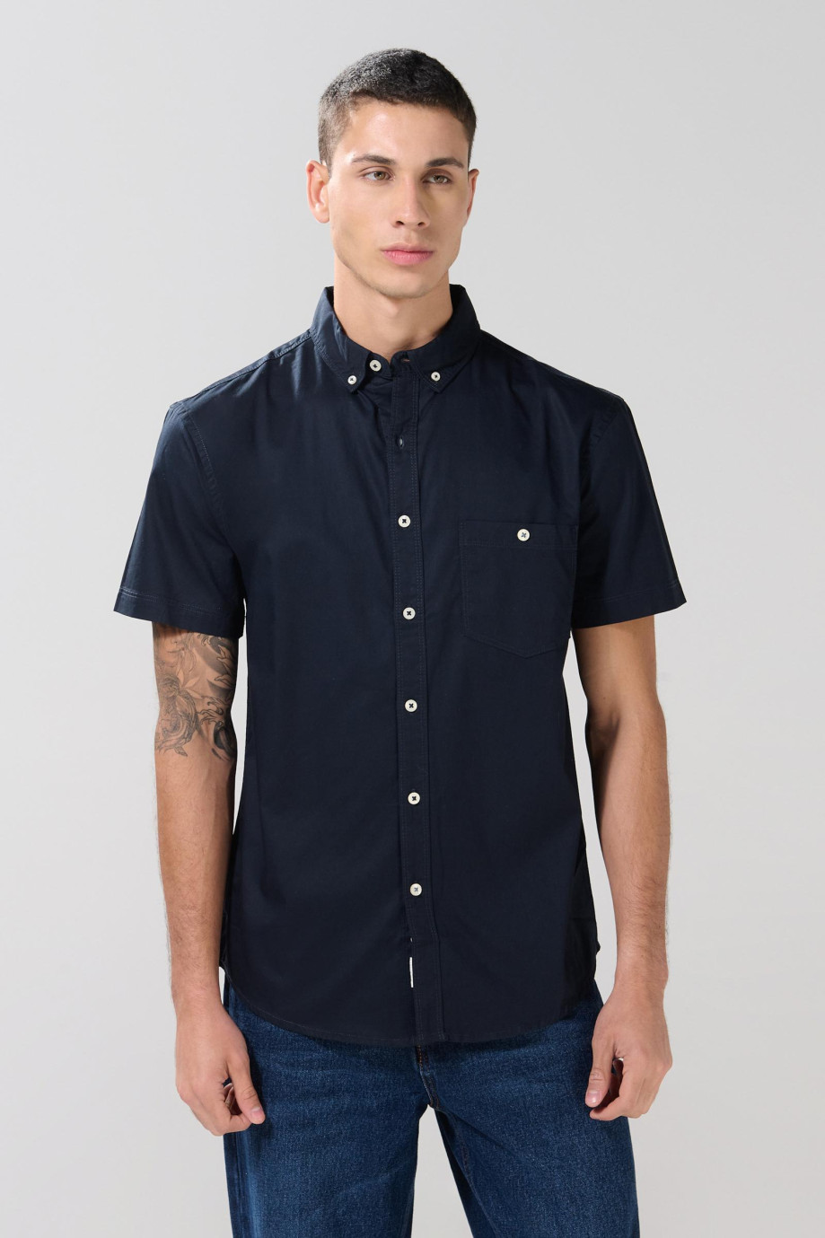 Camisa cuello button down unicolor con bolsillo delantero