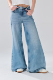 Jean flare azul claro con bota ancha, tiro medio y desgastes