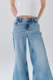 Jean flare azul claro con bota ancha, tiro medio y desgastes