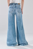 Jean flare azul claro con bota ancha, tiro medio y desgastes