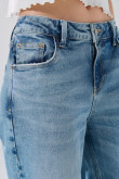 Jean flare azul claro con bota ancha, tiro medio y desgastes