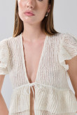 Blusa crema clara con escote V, manga corta y diseños