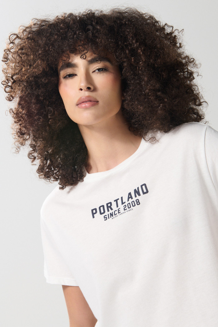 Camiseta crop top crema clara con texto college negro