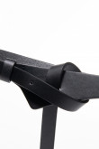 Cinturón delgado negro con hebilla metálica y cierre cruzado